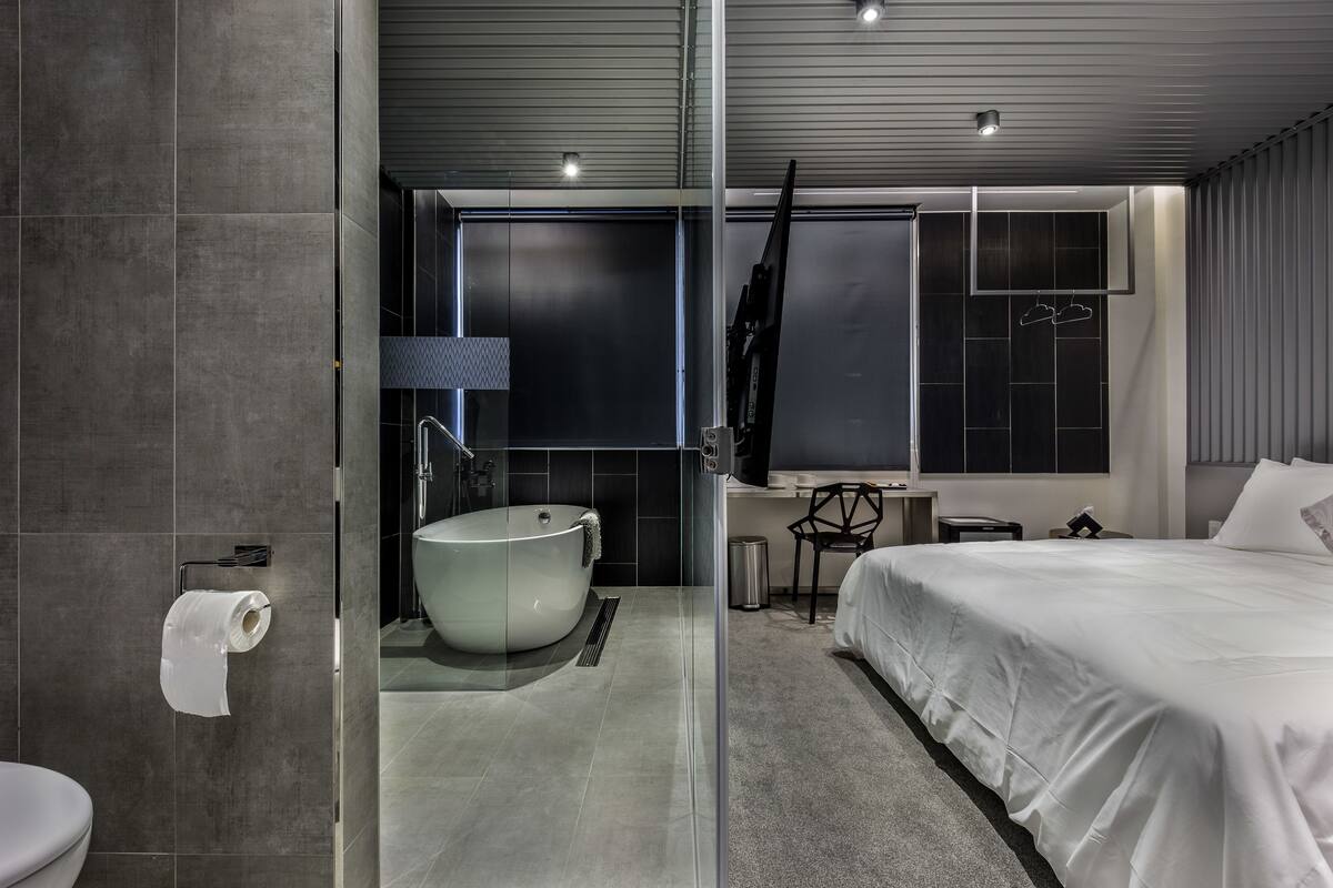 A modern bathroom with a freestanding bathtub, a toilet, and a shower area.