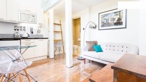 A modern apartment with a kitchen, a dining area, and a living room.