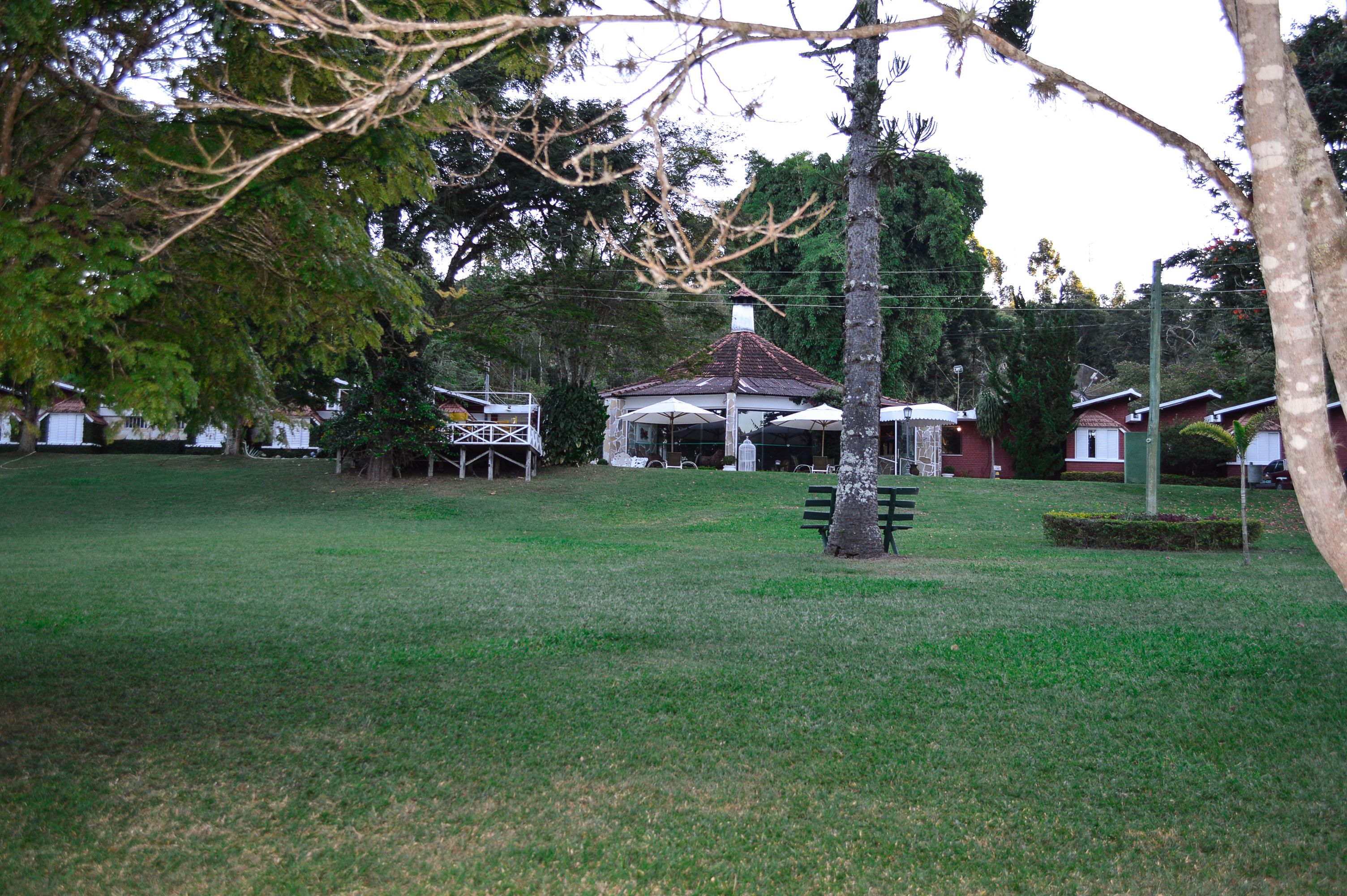 A gazebo in a park with a bench nearby.