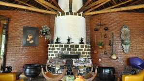 Una cocina rústica con chimenea de piedra, vigas de madera y utensilios de cocina antiguos.