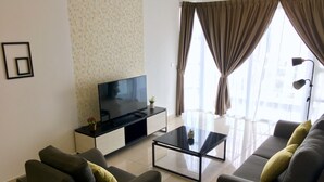 A modern living room with a flat-screen TV, a glass coffee table, and two sofas with cushions. - Pinnacle Tower Johor Bahru (Johor Bahru)