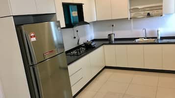 Condo familiar, 2 habitaciones, balcón | Cocina privada | Refrigerador con congelador, parrilla de estufa y cafetera y tetera