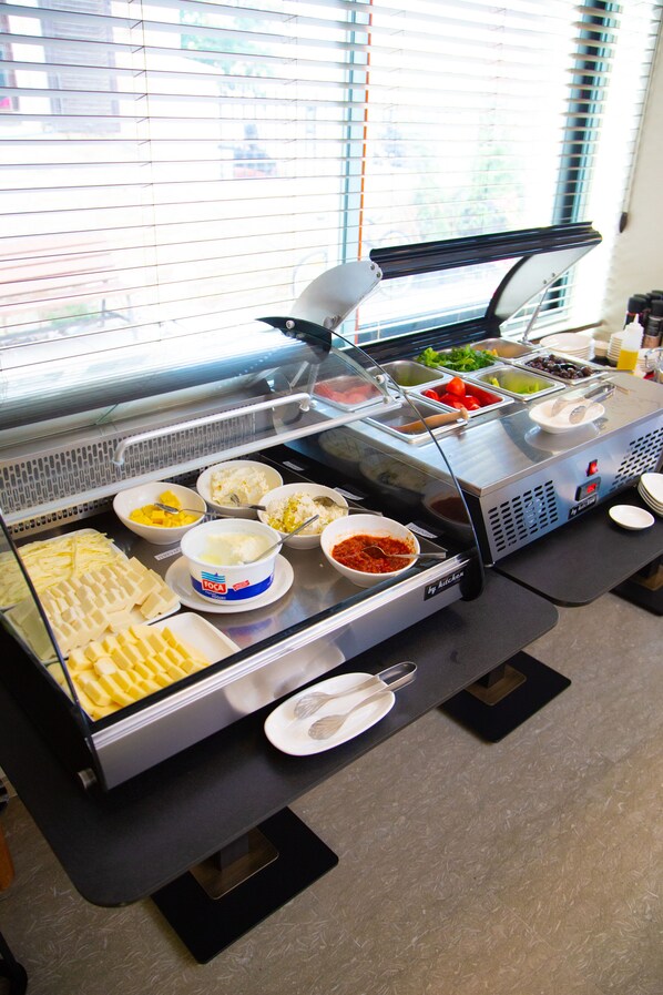 A buffet with various food items and a glass display case.