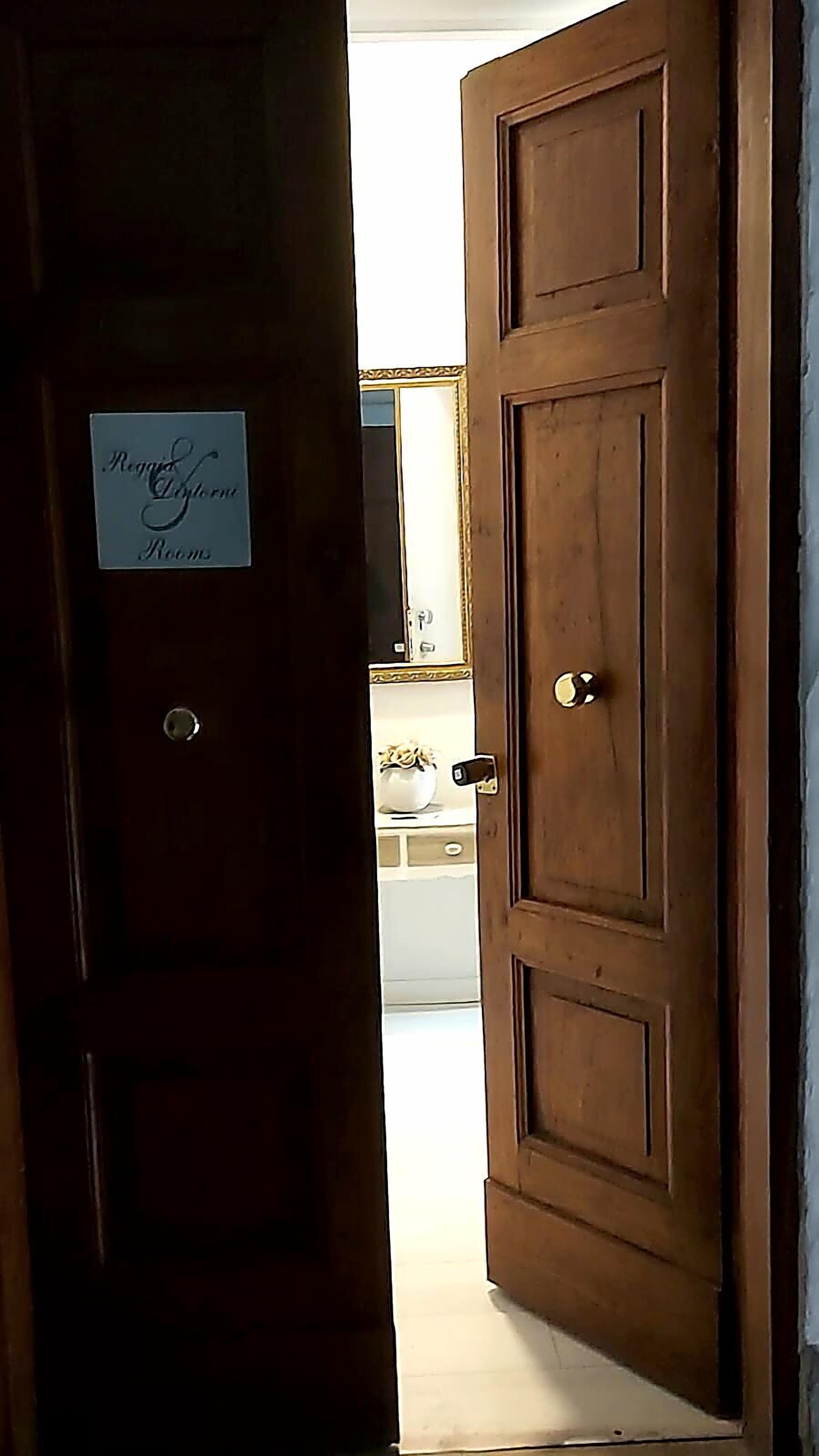 A wooden door with a sign reading "Regal Suite Rooms".