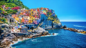 A coastal village with colorful buildings perched on a cliff overlooking the sea.
