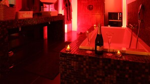 A bathroom with a tiled floor, a bathtub, a sink, and a mirror. There are candles on the counter. - Villa Margaux (Fargues-Saint-Hilaire)