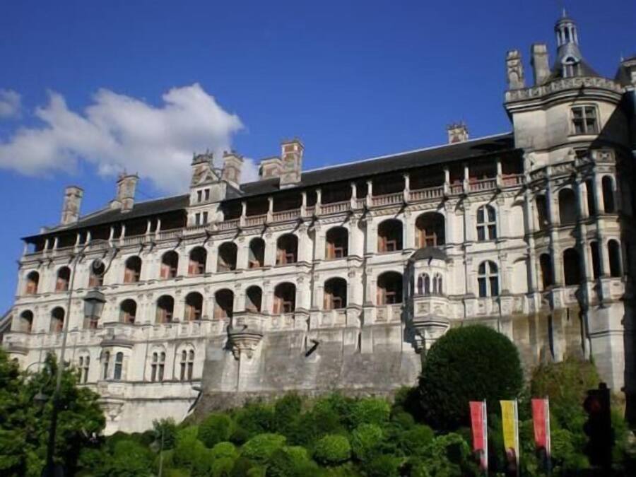 A large, historic building with multiple arches and a prominent tower.