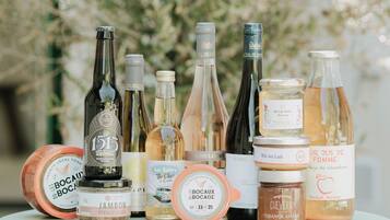 A selection of food and drink items, including bottles of wine and jars of preserves, displayed on a table.