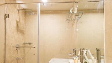 Ein modernes Badezimmer mit einer Glaskabine zur Dusche, zwei Waschbecken und einem großen Spiegel.