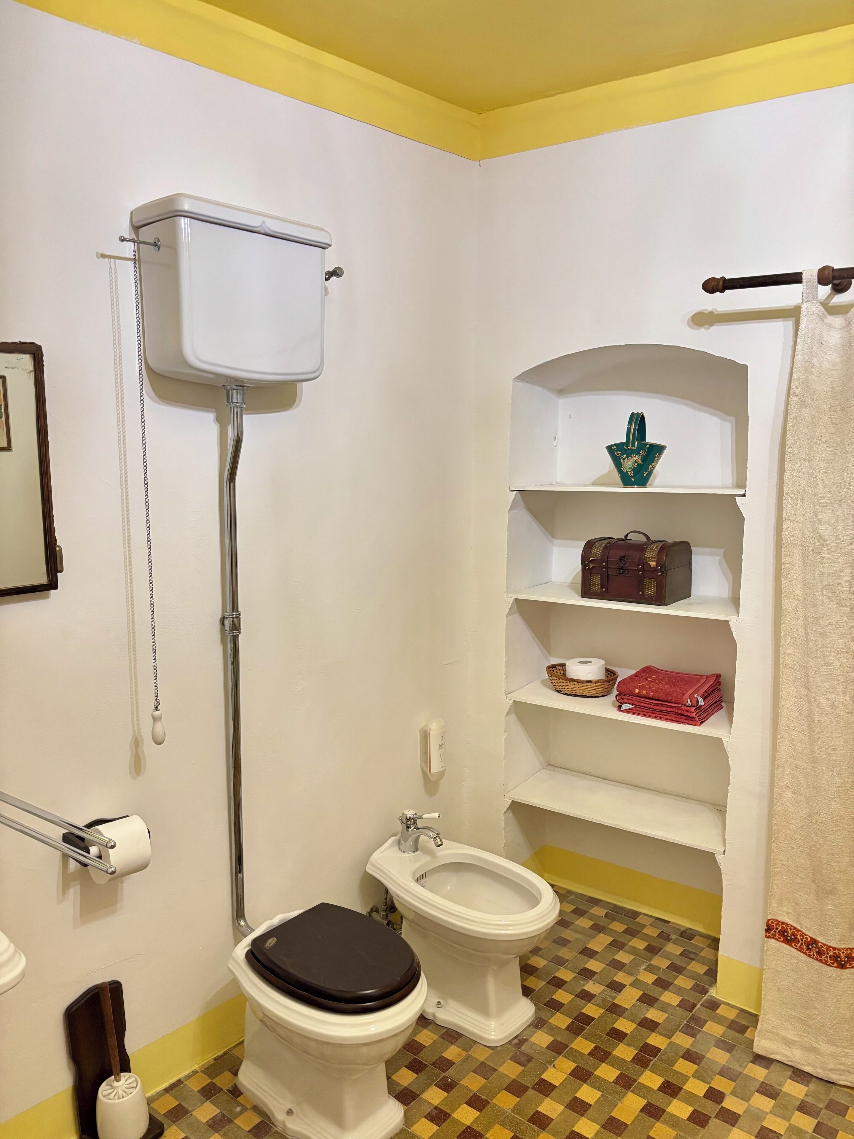 Ein Badezimmer mit Toilette, Bidet und Ablage für Toilettenartikel.