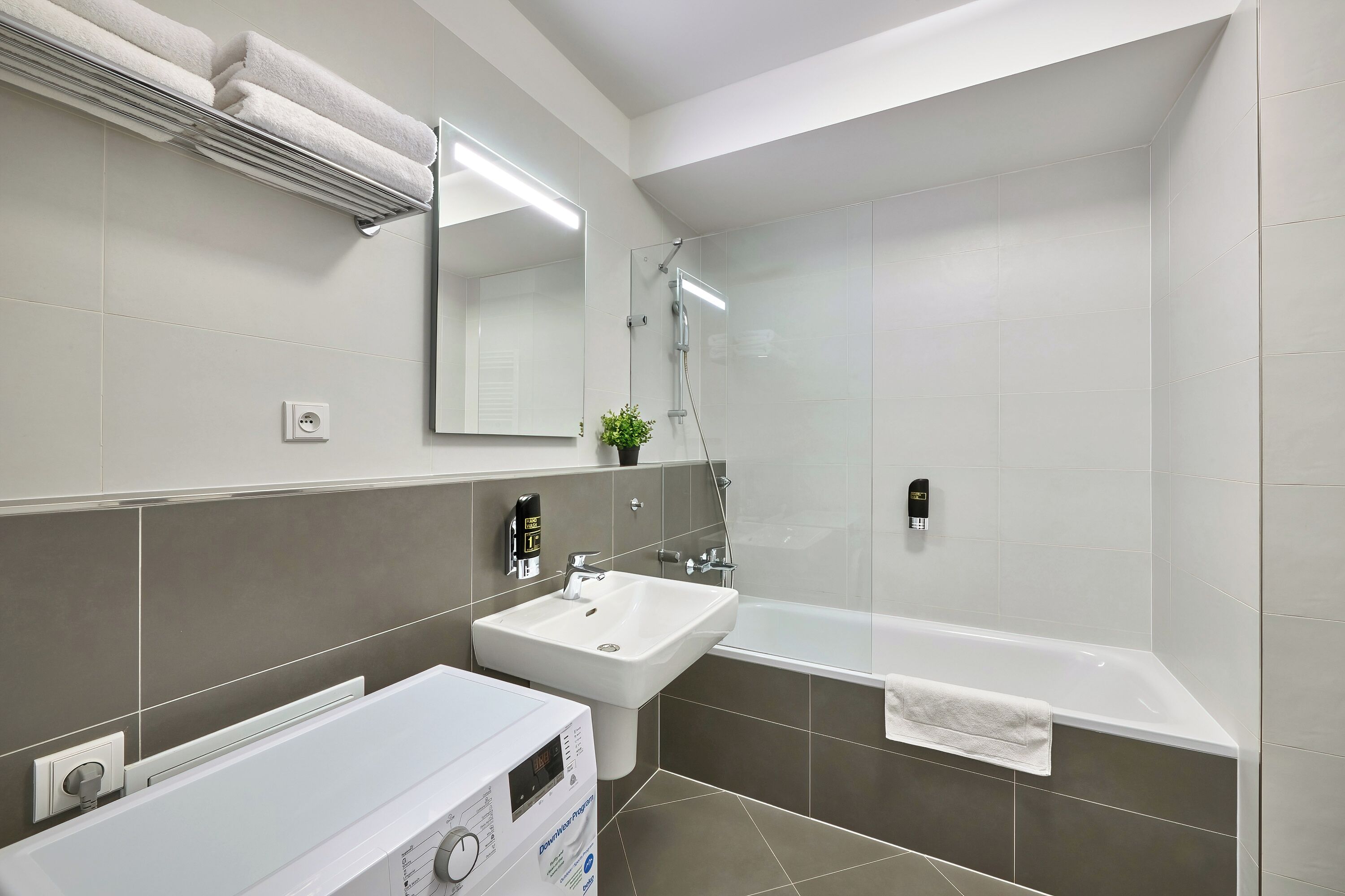 Une salle de bain moderne avec un lavabo, un miroir et une douche.