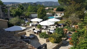 A courtyard with outdoor seating, umbrellas, and a pool.