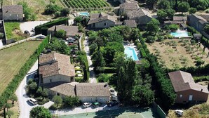 An aerial view of a residential area with houses, a swimming pool, and a tennis court.