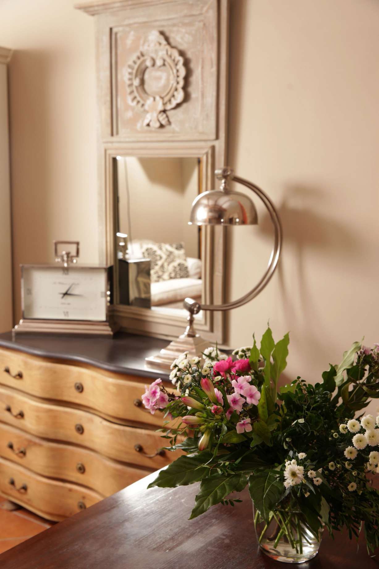 A wooden dresser with a clock and a mirror above it.