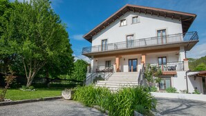 A two-story building with a balcony, a staircase leading to the entrance, and a gravel driveway. - Albergo della Corte (Pescasseroli)