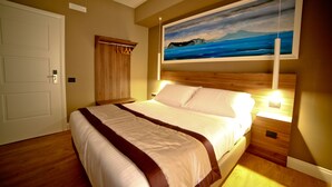 A bedroom with a large bed, wooden headboard, a painting of a landscape, and a door. - 7th Floor Suite (Naples)