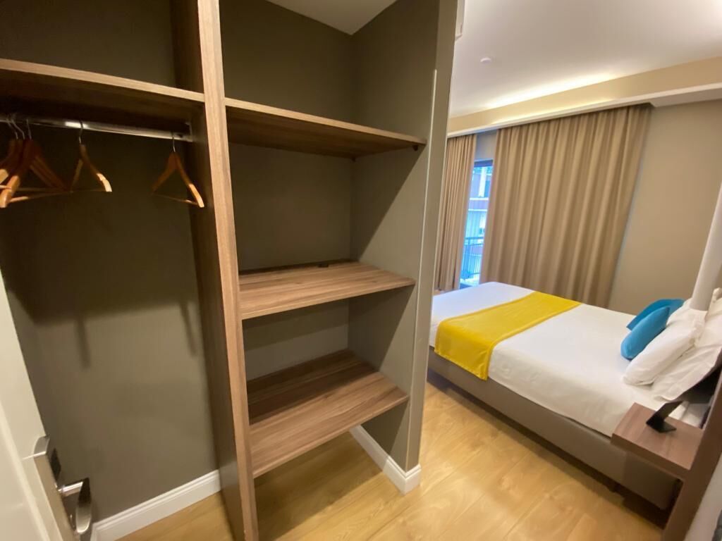 Une chambre à coucher avec un lit, une armoire et une fenêtre avec des rideaux.