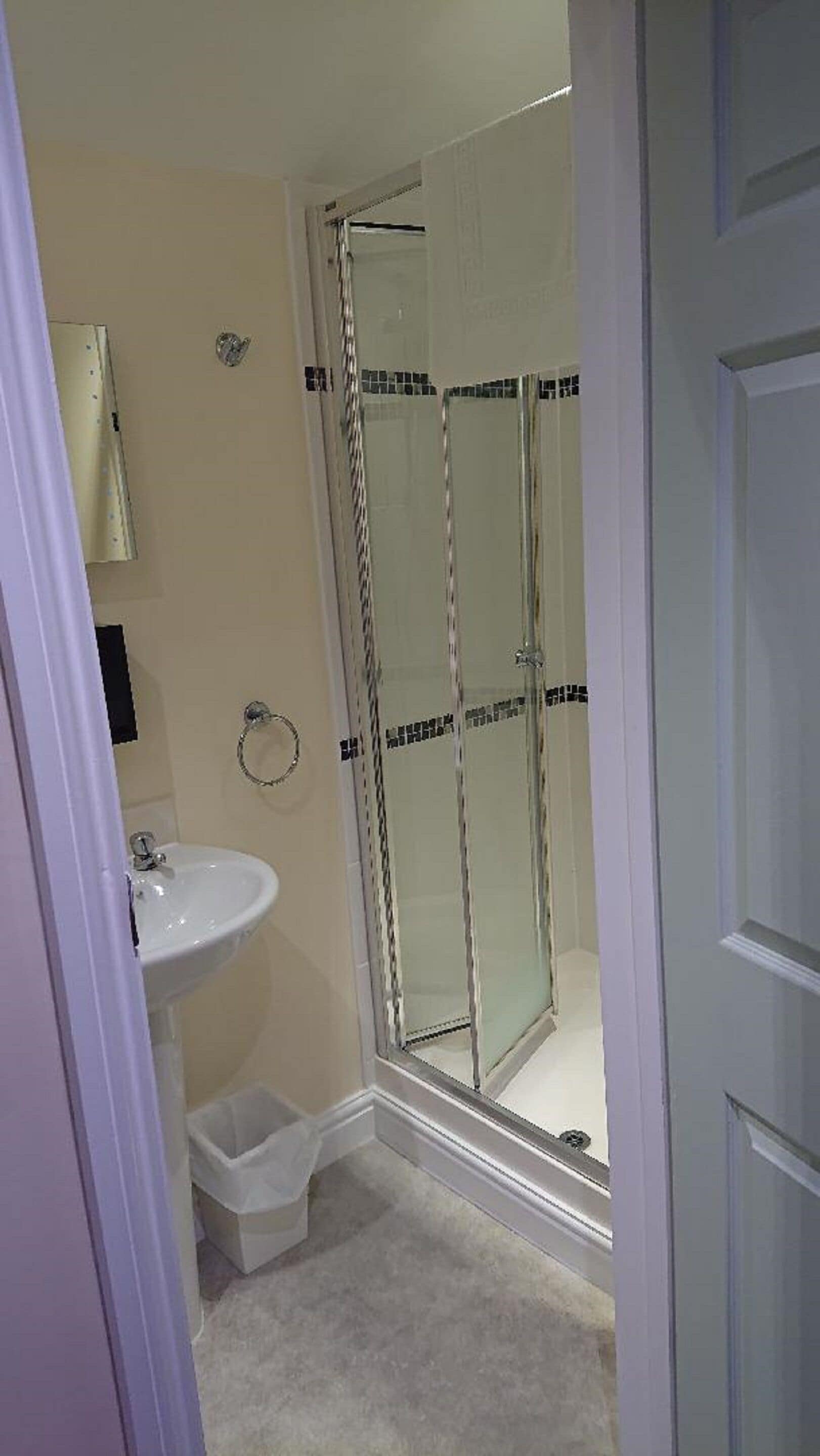 Une salle de bain avec une douche à parois de verre, un lavabo et des toilettes.