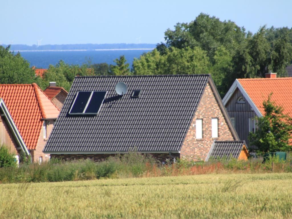 Ein Haus mit geneigtem Dach, Solaranlagen und einer Satellitenschüssel.