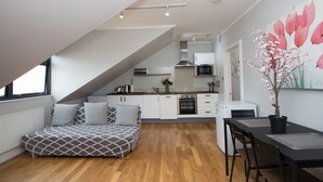 Ein modernes Loft-Apartment mit Schlafgalerie, Küchenzeile, Essbereich und großem Fenster.