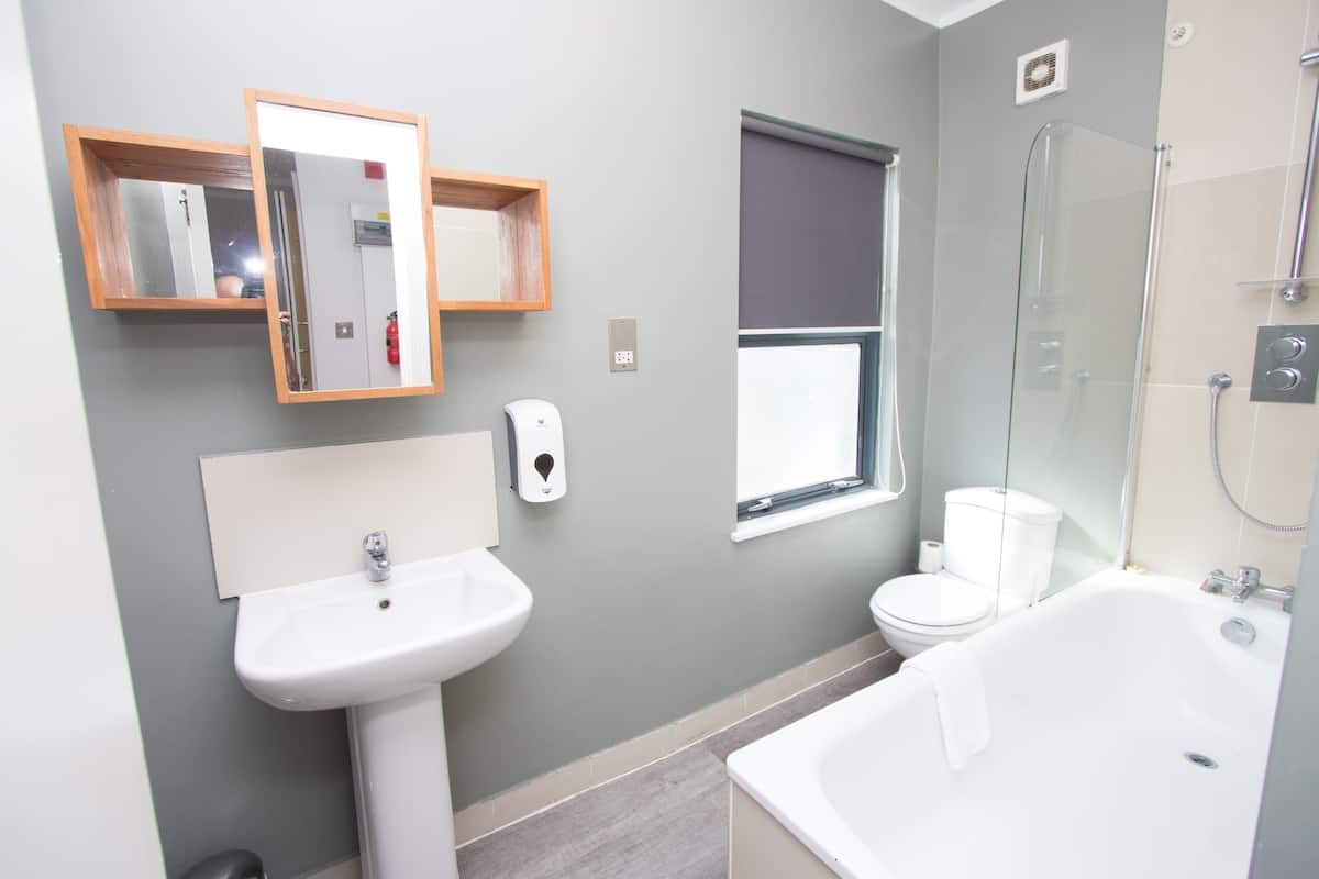 Een moderne badkamer met een wastafel, toilet en bad.