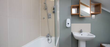 A modern bathroom with a bathtub, a sink, and a shower.