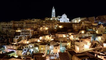 A historic town at night with illuminated buildings and a prominent church with a bell tower.