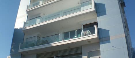 A multi-story building with balconies, large windows, and a flat facade.