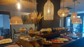 Un buffet proposant une variété de plats, des suspensions en rotin et une vitrine en verre transparent.