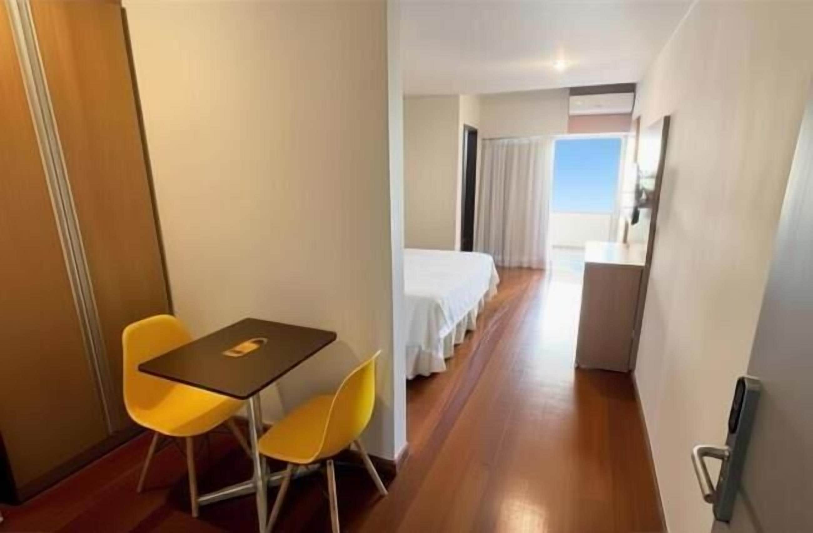 Una habitación de hotel con cama, escritorio y una silla.