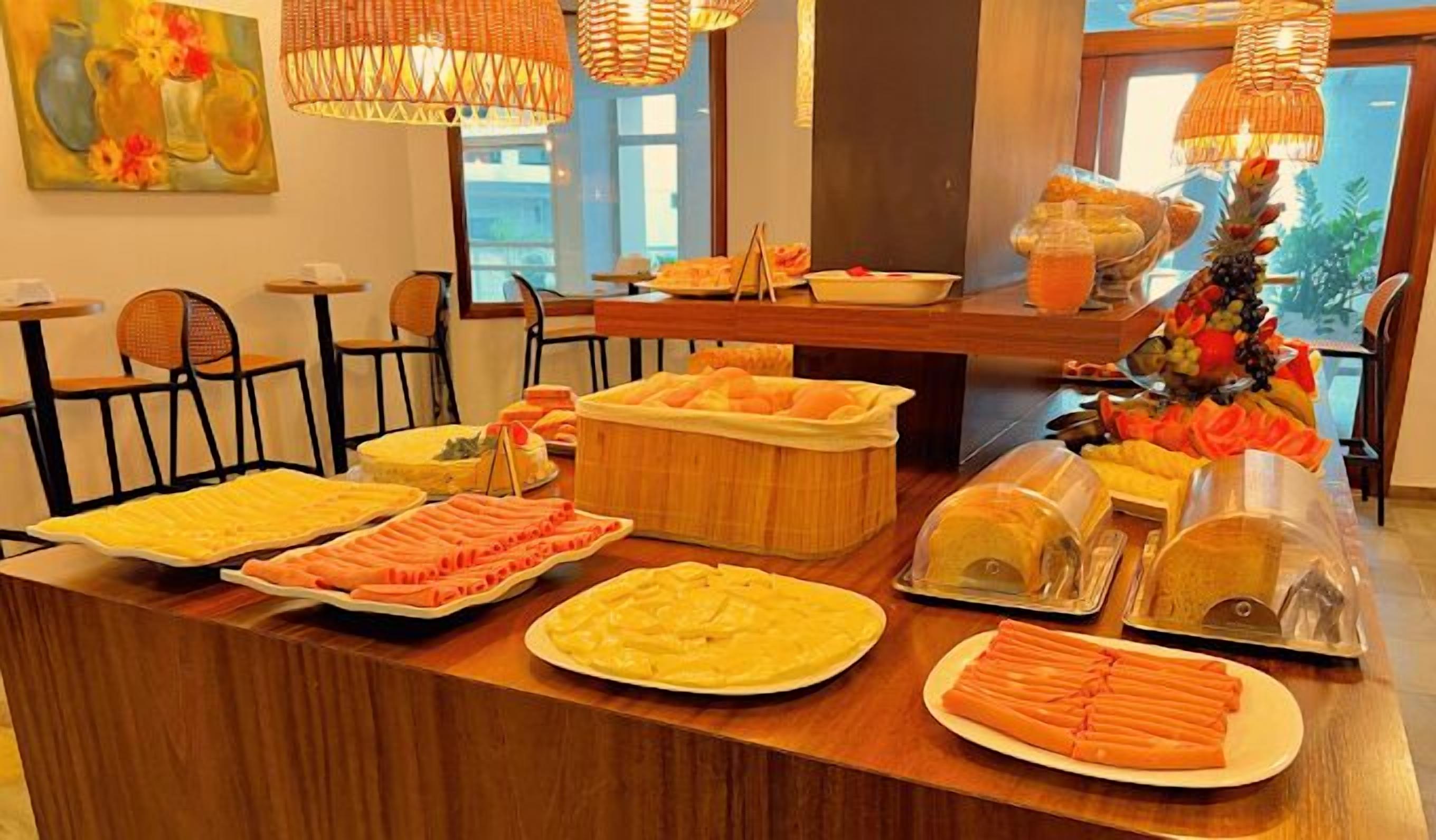 Montaje de bufé con diversos alimentos y un centro de mesa decorativo.