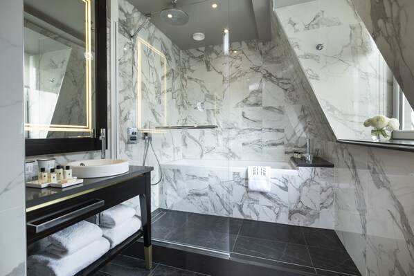 Un baño moderno con tocador de mármol, bañera y ducha.