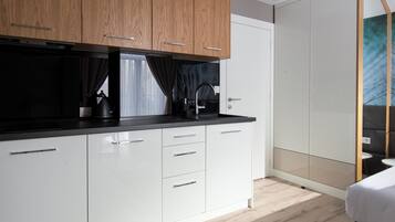 A modern kitchen with white cabinets, a black countertop, and a built-in oven.