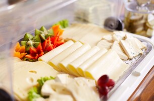 Un buffet con diversi cibi, tra cui frutta e verdura tagliate.