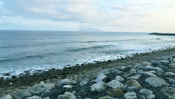 A rocky shoreline with waves crashing onto the beach. - Migratory Birds Hotel (Toucheng)
