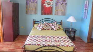 Un dormitorio con una cama, una mesita de noche, una lámpara y un armario.