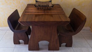 A wooden dining table with a woven center, accompanied by two chairs. - Wellington Cove (Kingston)