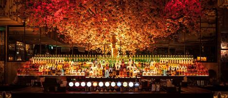 A bar with a large tree display and numerous bottles of liquor.