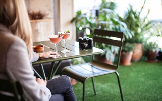 Una persona sentada a una mesa con dos bebidas y una cámara.
