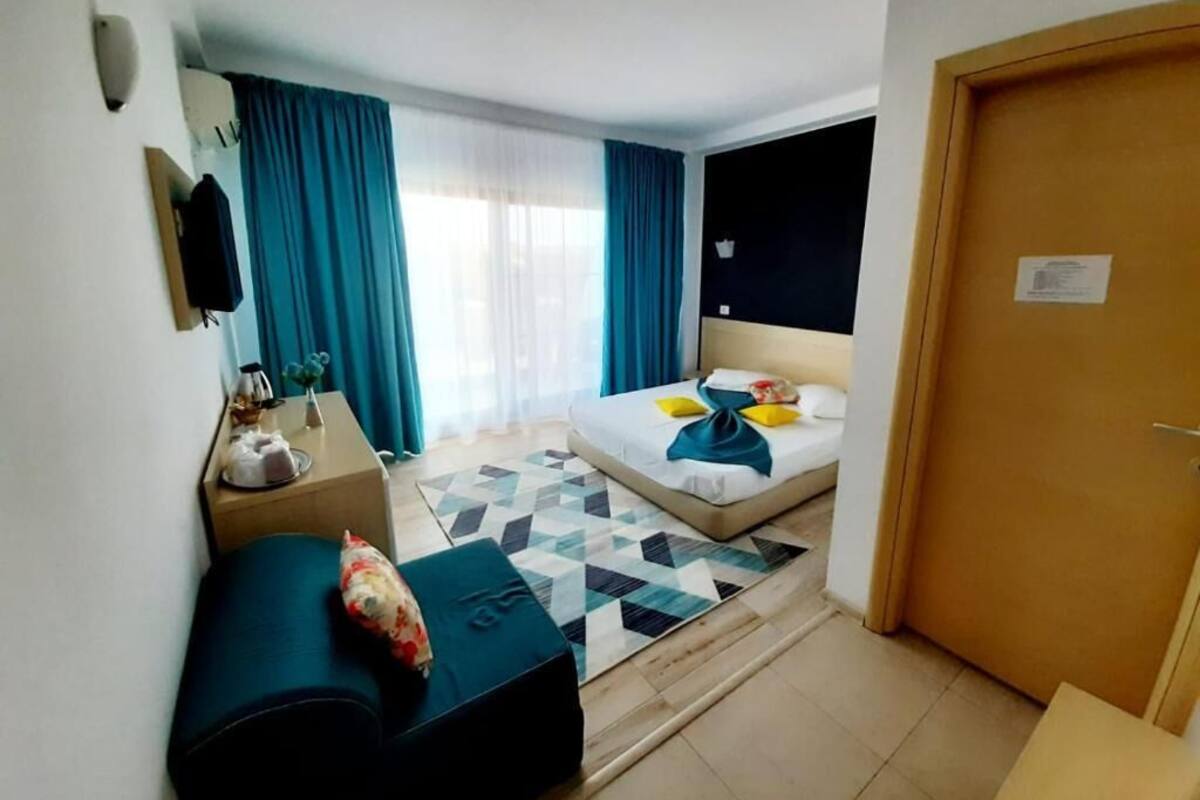 Ein Hotelzimmer mit Bett, Schreibtisch, Stuhl und einem kleinen Tisch.