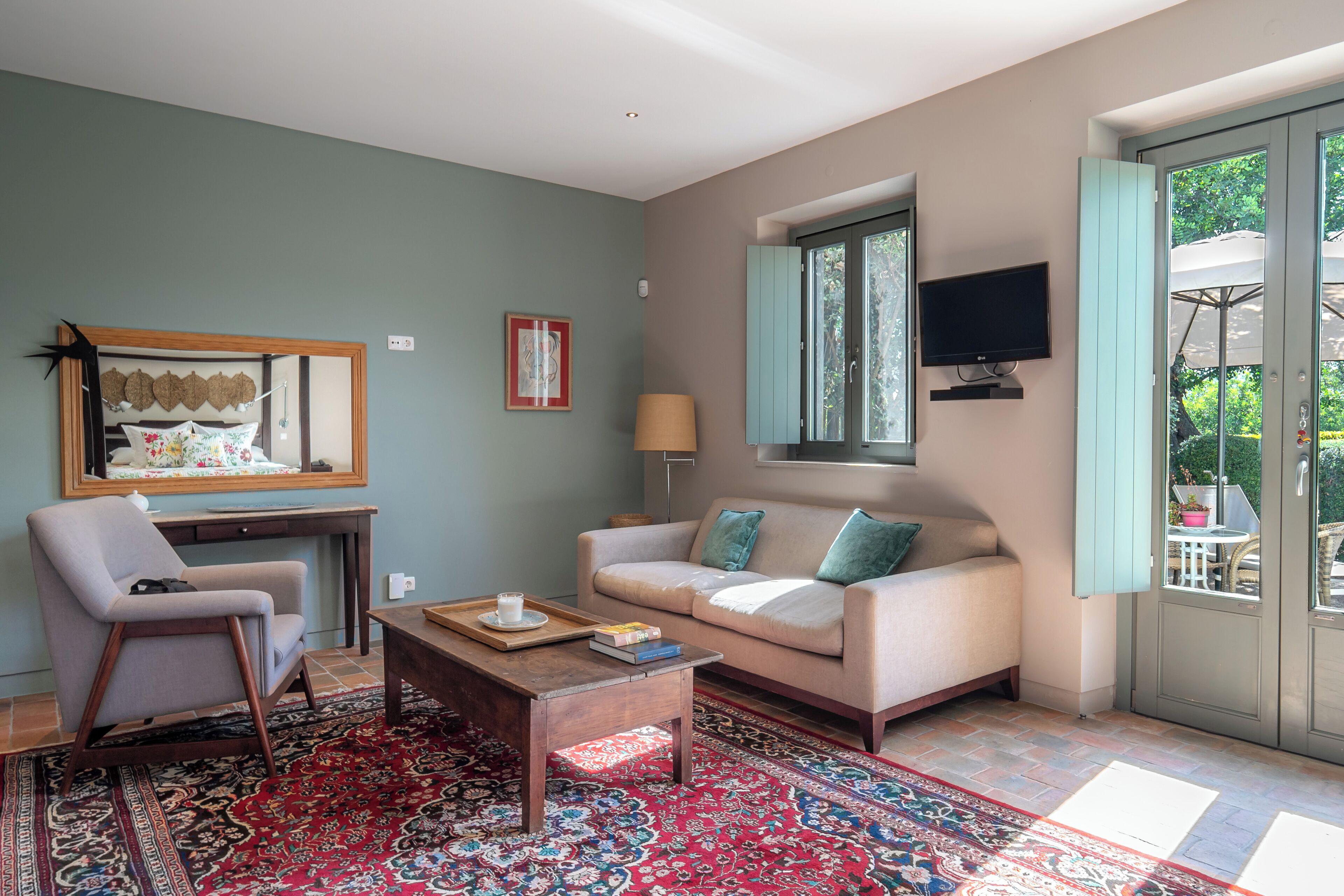 Ein Wohnzimmer mit einer Couch, einem Sessel, einem Couchtisch und einem großen Teppich.