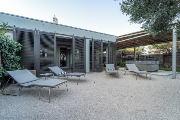 An outdoor patio with modern lounge chairs and a hot tub. - Fazenda Nova - Country House (Tavira)