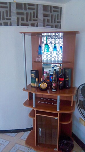 A multi-tiered wooden shelf unit with various bottles and containers, likely for storage or display.