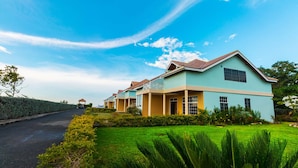 A row of light blue houses with a well-maintained lawn and a clear sky. - Paradise  Beach Front Apartment (Discovery Bay)