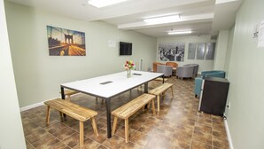 A conference room with a long table, wooden benches, and a vase with flowers. - Canal Loft Hotel (New York)