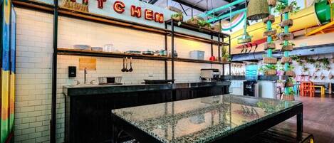 A modern kitchen with a black countertop, white tiled walls, and a sign that reads "KITCHEN".