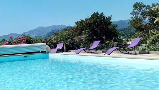 A swimming pool with a view of mountains in the background. - Chambres d'hôtes Anousta (Loubajac)