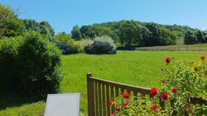 A grassy field with a wooden gate and blooming red flowers. - Chambres d'hôtes Anousta (Loubajac)