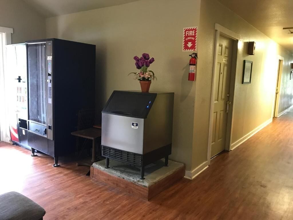 A kitchen with a built-in stove, a refrigerator, and a flower vase on the counter.