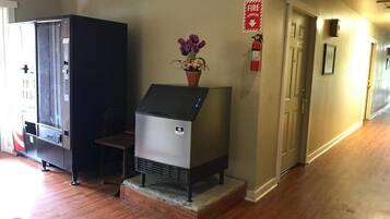 A kitchen with a built-in stove, a refrigerator, and a flower vase on the counter.